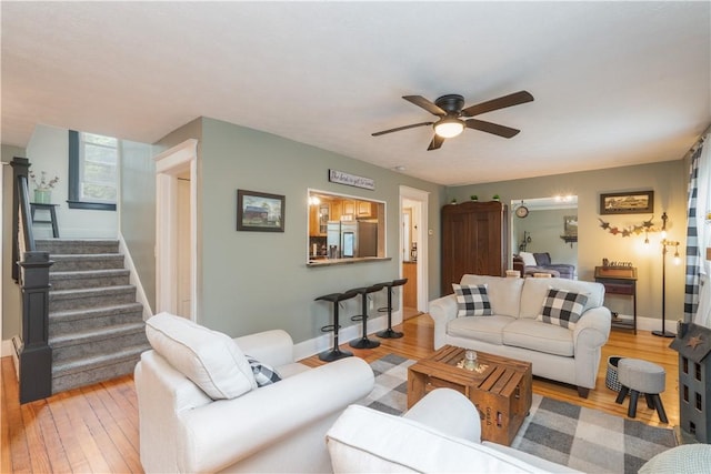 70 E Main St, Avon, NY 14414 - living room featuring a ceiling fan, light wood finished floors, and stairway