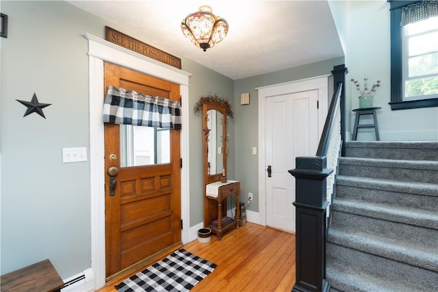 70 E Main St, Avon, NY 14414 - entryway with a baseboard heating unit, stairway, and light wood-style floors