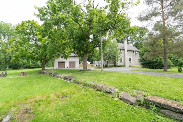 70 E Main St, Avon, NY 14414 - view of grassy yard with an attached garage and driveway