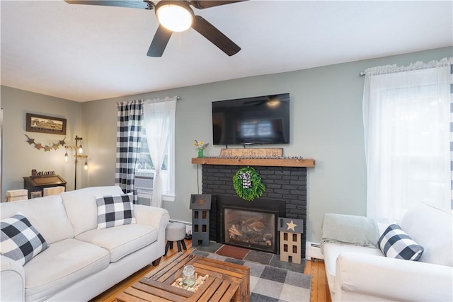 70 E Main St, Avon, NY 14414 - living room featuring a baseboard radiator, ceiling fan, a brick fireplace, and wood finished floors