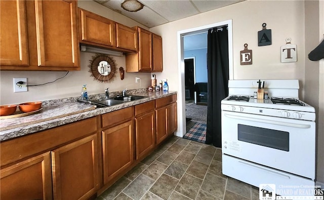 296 Falconer St, Jamestown, NY 14701 - kitchen with gas range gas stove, brown cabinetry, dark stone finish floors, and a drop ceiling