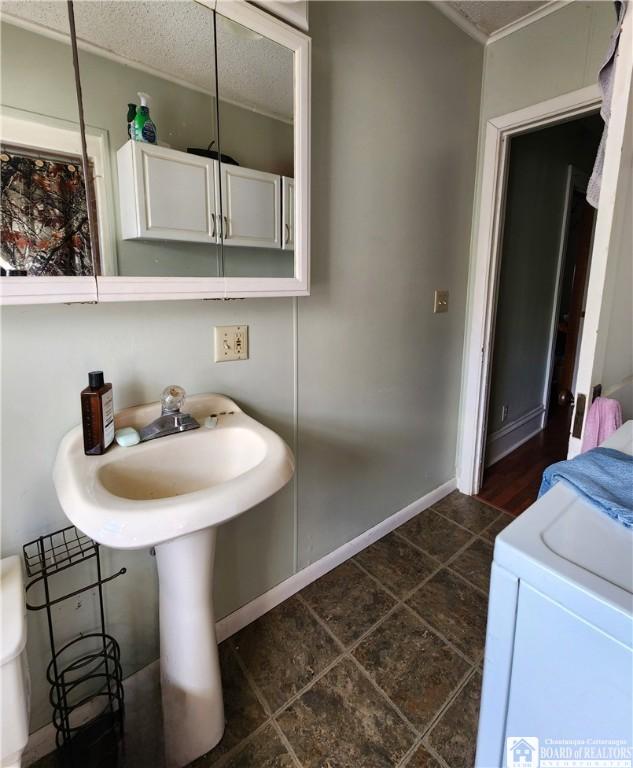 124 Bowen St, Jamestown, NY 14701 - bathroom featuring ornamental molding and washer / dryer