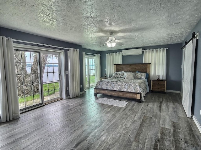 641 Fire Ln Unit 5, Genoa, NY 13081 - bedroom featuring a barn door, access to exterior, wood finished floors, a wall mounted air conditioner, and a textured ceiling