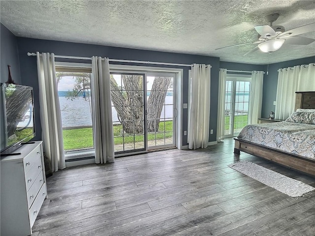 641 Fire Ln Unit 5, Genoa, NY 13081 - bedroom with access to outside, wood-type flooring, multiple windows, a textured ceiling, and ceiling fan