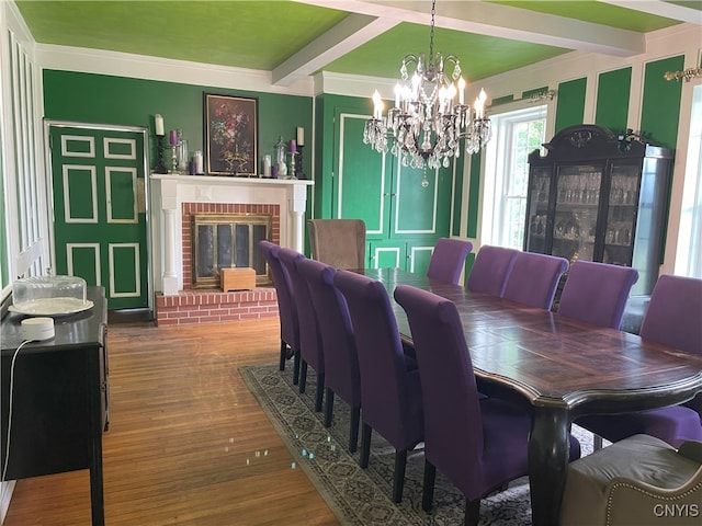 11159 State Route 34, Cato, NY 13033 - dining room with a chandelier, beam ceiling, wood finished floors, ornamental molding, and a brick fireplace