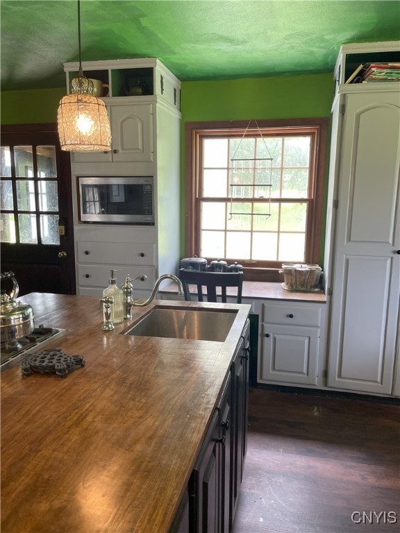 11159 State Route 34, Cato, NY 13033 - kitchen featuring stainless steel microwave, plenty of natural light, decorative light fixtures, dark wood-type flooring, and a textured ceiling