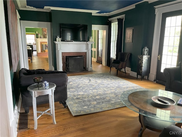 11159 State Route 34, Cato, NY 13033 - living area with crown molding, plenty of natural light, wood finished floors, and a brick fireplace