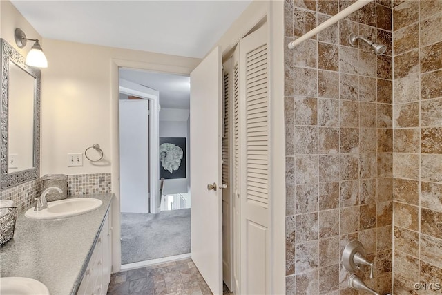 4853 Enders Rd, Manlius, NY 13104 - full bath with double vanity, a closet, stone finish flooring, and backsplash