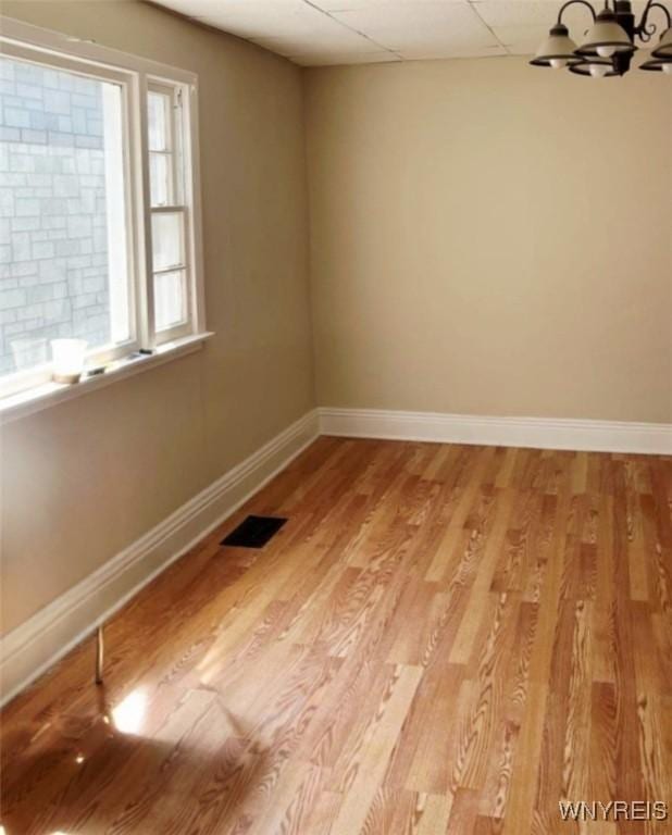 50 Ideal St, Buffalo, NY 14206 - unfurnished room with light wood-style flooring, a chandelier, and a drop ceiling