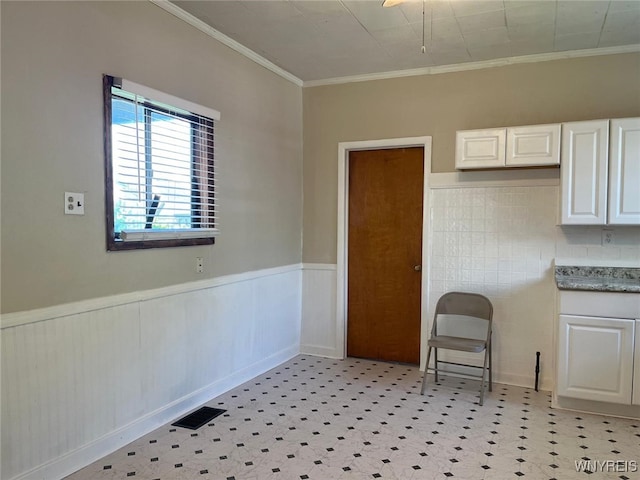 50 Ideal St, Buffalo, NY 14206 - unfurnished dining area featuring ornamental molding, light floors, and a wainscoted wall