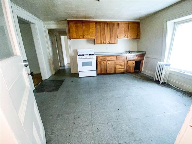 866 Smith St, Rochester, NY 14606 - kitchen featuring white range oven, radiator, brown cabinets, and light countertops