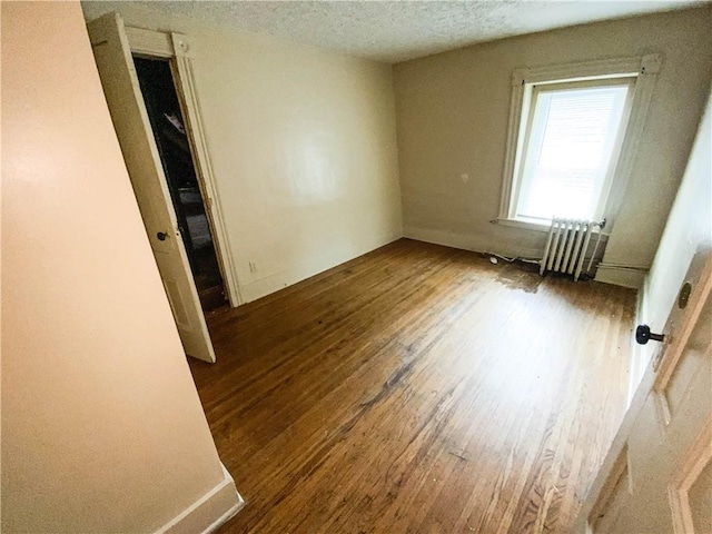 866 Smith St, Rochester, NY 14606 - spare room featuring radiator, wood finished floors, and a textured ceiling