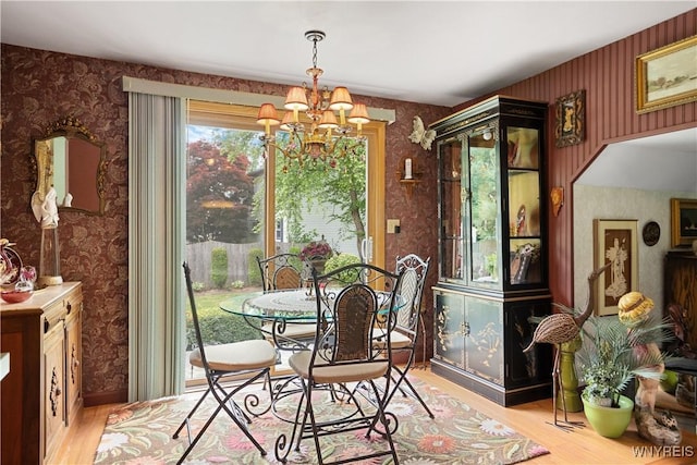 7438 Thunderbird Rd, Clay, NY 13088 - dining area with wallpapered walls, light wood-type flooring, and a chandelier
