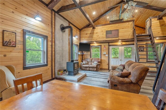 45 Fawn Lake Rd, Orwell, NY 13302 - living room featuring a wood ceiling with exposed beams, wooden walls, a wood stove, ceiling fan, and wood finished floors