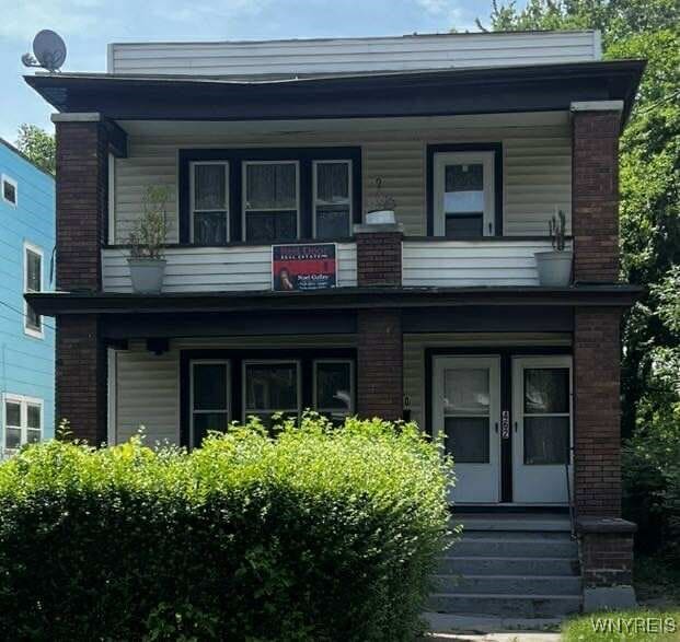 460 9th St, Niagara Falls, NY 14303 - view of front facade with a balcony, french doors, and a porch