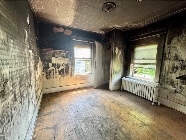 553 Denise Rd, Greece, NY 14616 - unfurnished room with radiator, wood-type flooring, and healthy amount of natural light