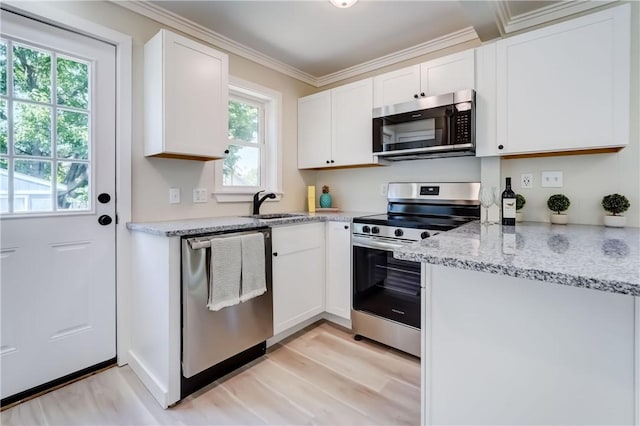 331 E Commercial St, East Rochester, NY 14445 - kitchen with stainless steel appliances, light wood-type flooring, crown molding, white cabinetry, and light stone countertops