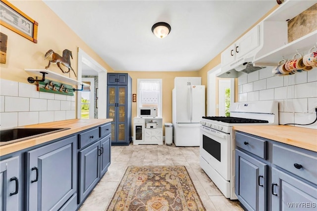 3121 Maple Rd, Wilson, NY 14108 - kitchen with white appliances, wooden counters, blue cabinetry, and backsplash