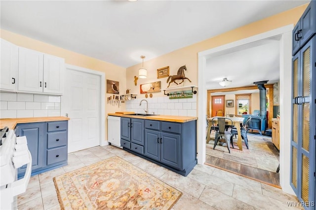 3121 Maple Rd, Wilson, NY 14108 - kitchen with wooden counters, white dishwasher, tasteful backsplash, blue cabinetry, and open shelves
