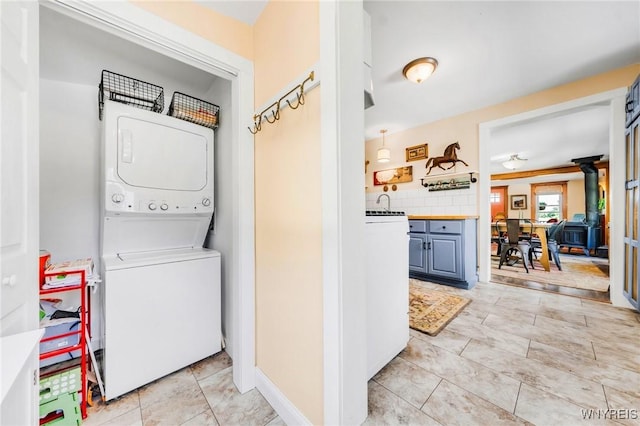 3121 Maple Rd, Wilson, NY 14108 - laundry area with stacked washer / dryer and a wood stove