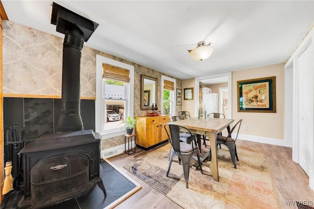 3121 Maple Rd, Wilson, NY 14108 - dining area with a wood stove and light wood-type flooring
