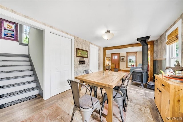 3121 Maple Rd, Wilson, NY 14108 - dining area with a wood stove, stairs, and light wood finished floors