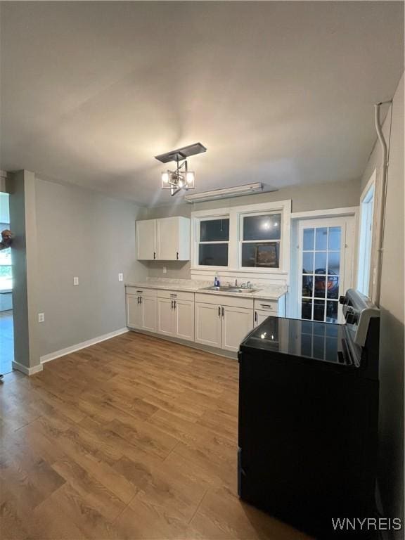 43 Union St, Collins, NY 14070 - kitchen with white cabinets, light wood-style floors, electric range, and light countertops
