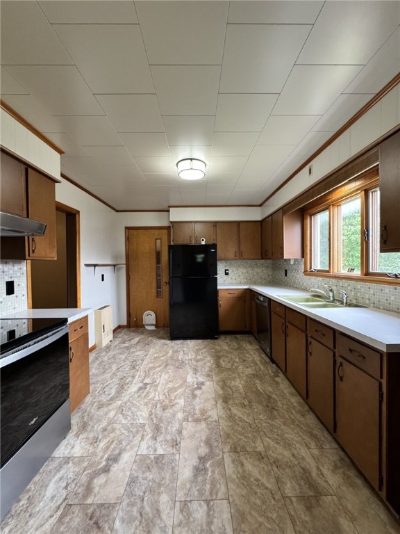 519 N Elk Ave, Kane Boro, PA 16735 - kitchen with freestanding refrigerator, electric range, backsplash, light countertops, and under cabinet range hood