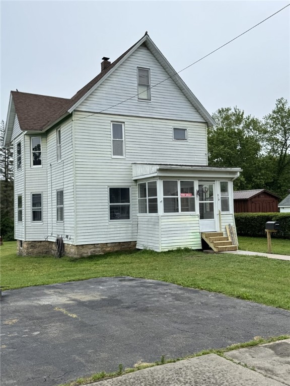 519 N Elk Ave, Kane Boro, PA 16735 - back of property featuring a sunroom, a chimney, entry steps, a lawn, and roof with shingles