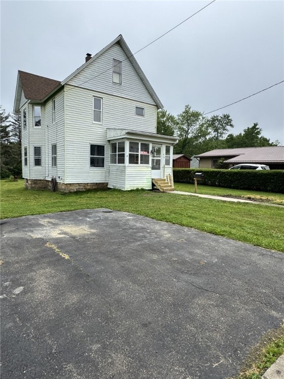 519 N Elk Ave, Kane Boro, PA 16735 - rear view of property featuring entry steps, a sunroom, a lawn, and a chimney