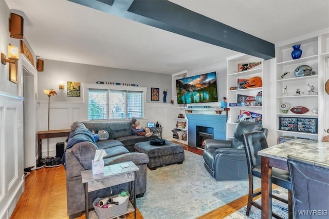 592 Parkside Ave, Buffalo, NY 14216 - living area featuring a fireplace with flush hearth, wood finished floors, wainscoting, and a decorative wall