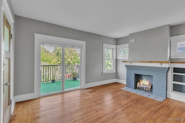 592 Parkside Ave, Buffalo, NY 14216 - unfurnished living room featuring healthy amount of natural light, wood finished floors, and a fireplace