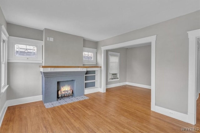 592 Parkside Ave, Buffalo, NY 14216 - unfurnished living room with a brick fireplace, wood finished floors, and cooling unit