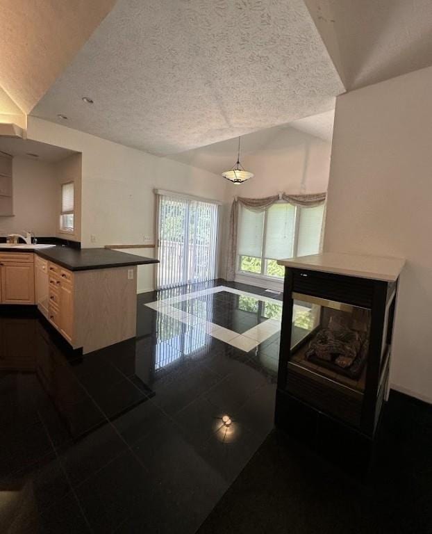 80 Endicar Dr, Irondequoit, NY 14622 - kitchen featuring dark countertops, lofted ceiling, a textured ceiling, pendant lighting, and dark tile patterned flooring