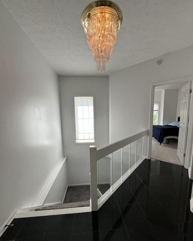 80 Endicar Dr, Irondequoit, NY 14622 - stairway featuring a textured ceiling, a chandelier, and granite floors