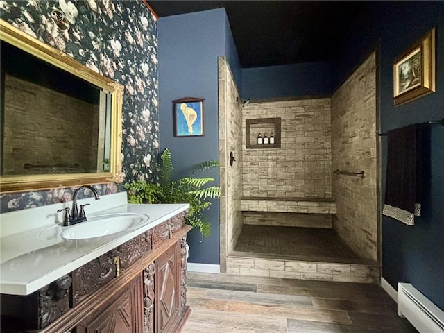 35799 State Highway 10, Hamden, NY 13782 - full bathroom featuring a baseboard heating unit, vanity, tiled shower, and wood finished floors