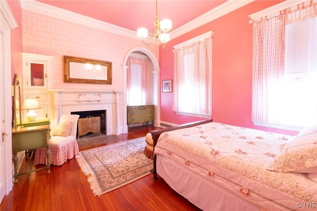 71 Forman St, Cazenovia, NY 13035 - bedroom featuring ornamental molding, a fireplace with flush hearth, wood finished floors, arched walkways, and a chandelier