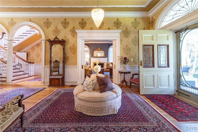 71 Forman St, Cazenovia, NY 13035 - entrance foyer featuring wallpapered walls, wood finished floors, crown molding, wainscoting, and a decorative wall