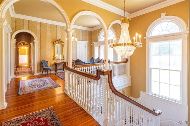 71 Forman St, Cazenovia, NY 13035 - hall with arched walkways, a chandelier, ornamental molding, wood finished floors, and decorative columns