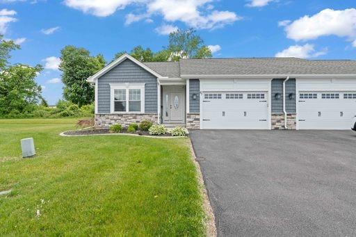 61 Kirkdale Cir, Greece, NY 14612 - view of front of home featuring driveway, an attached garage, a front lawn, and stone siding