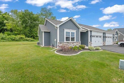 61 Kirkdale Cir, Greece, NY 14612 - view of front facade featuring an attached garage, asphalt driveway, a front yard, and stone siding