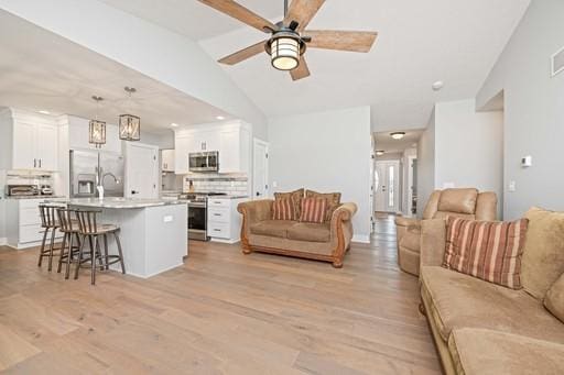 61 Kirkdale Cir, Greece, NY 14612 - living room featuring lofted ceiling, a ceiling fan, and light wood-style flooring