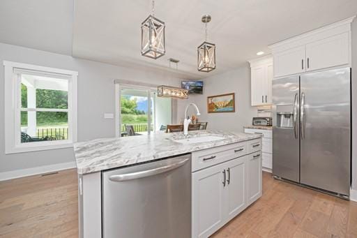 61 Kirkdale Cir, Greece, NY 14612 - kitchen featuring stainless steel appliances, light wood-style floors, light stone counters, and white cabinetry