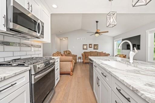 61 Kirkdale Cir, Greece, NY 14612 - kitchen featuring stainless steel appliances, vaulted ceiling, white cabinets, a ceiling fan, and light wood-type flooring
