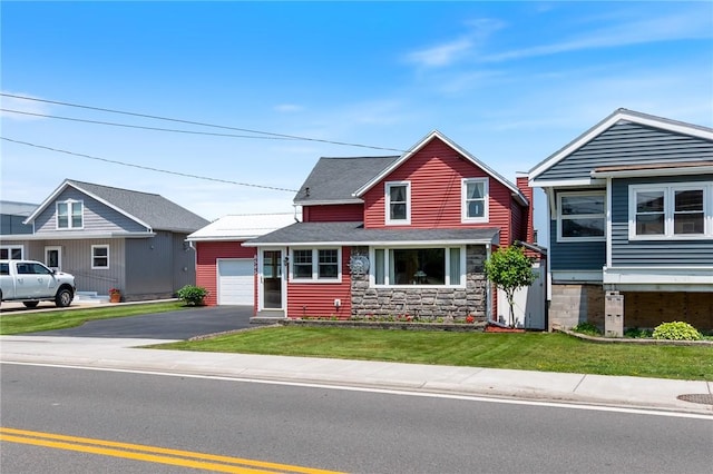 8545 Greig St, Sodus, NY 14555 - view of front of property featuring a garage, a front yard, a shingled roof, stone siding, and an outdoor structure