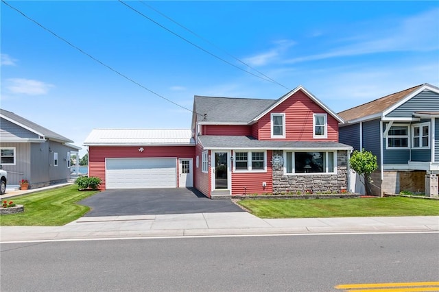 8545 Greig St, Sodus, NY 14555 - traditional-style home featuring an attached garage, driveway, stone siding, and a front yard