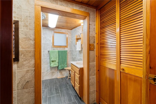 8545 Greig St, Sodus, NY 14555 - bathroom featuring vanity, wooden ceiling, tile patterned floors, tile walls, and a closet