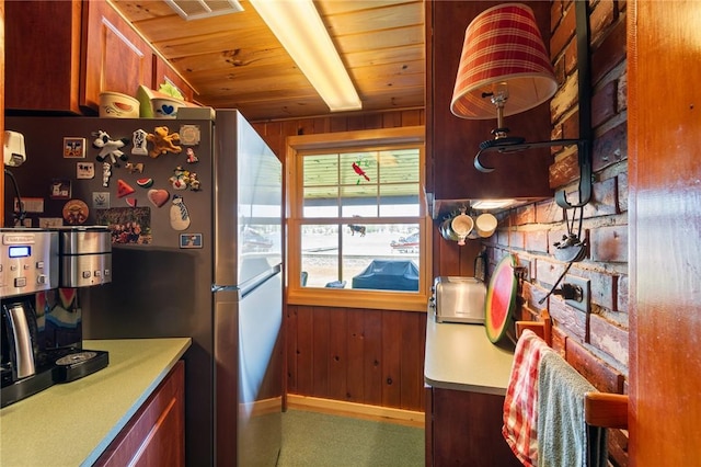 8545 Greig St, Sodus, NY 14555 - kitchen featuring freestanding refrigerator, wood ceiling, wooden walls, and carpet