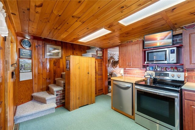 8545 Greig St, Sodus, NY 14555 - kitchen featuring appliances with stainless steel finishes, light carpet, wooden ceiling, light countertops, and wooden walls