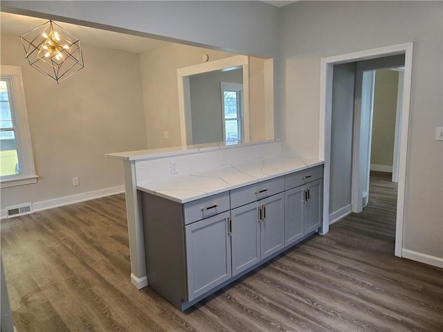 41 Garnet St, Rochester, NY 14609 - kitchen with gray cabinets, a chandelier, dark wood-style flooring, light stone countertops, and a peninsula